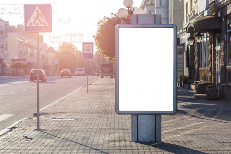 Empty Billboard On Urban Pavement In Sunshine