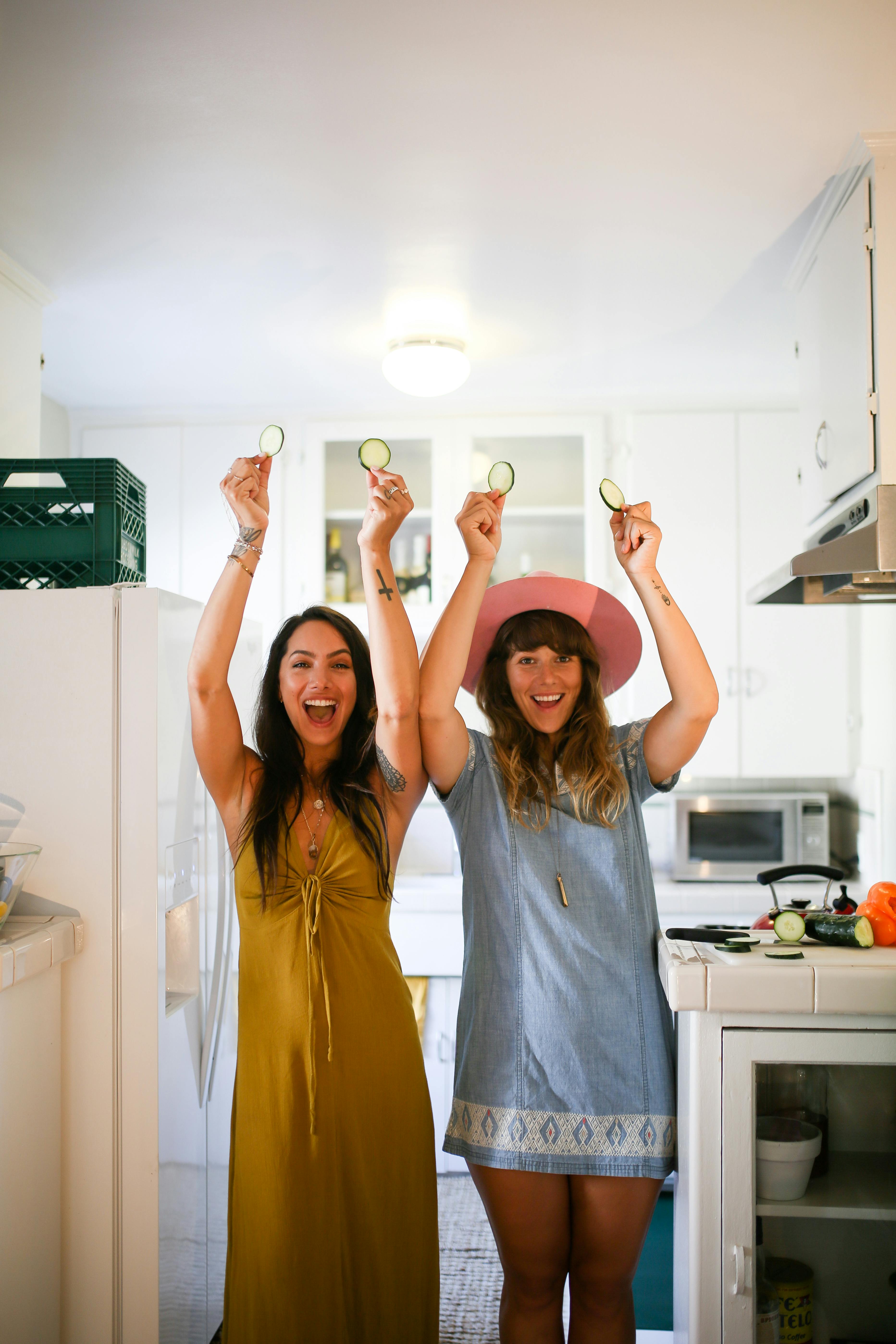 happy women holding sliced cucumbers