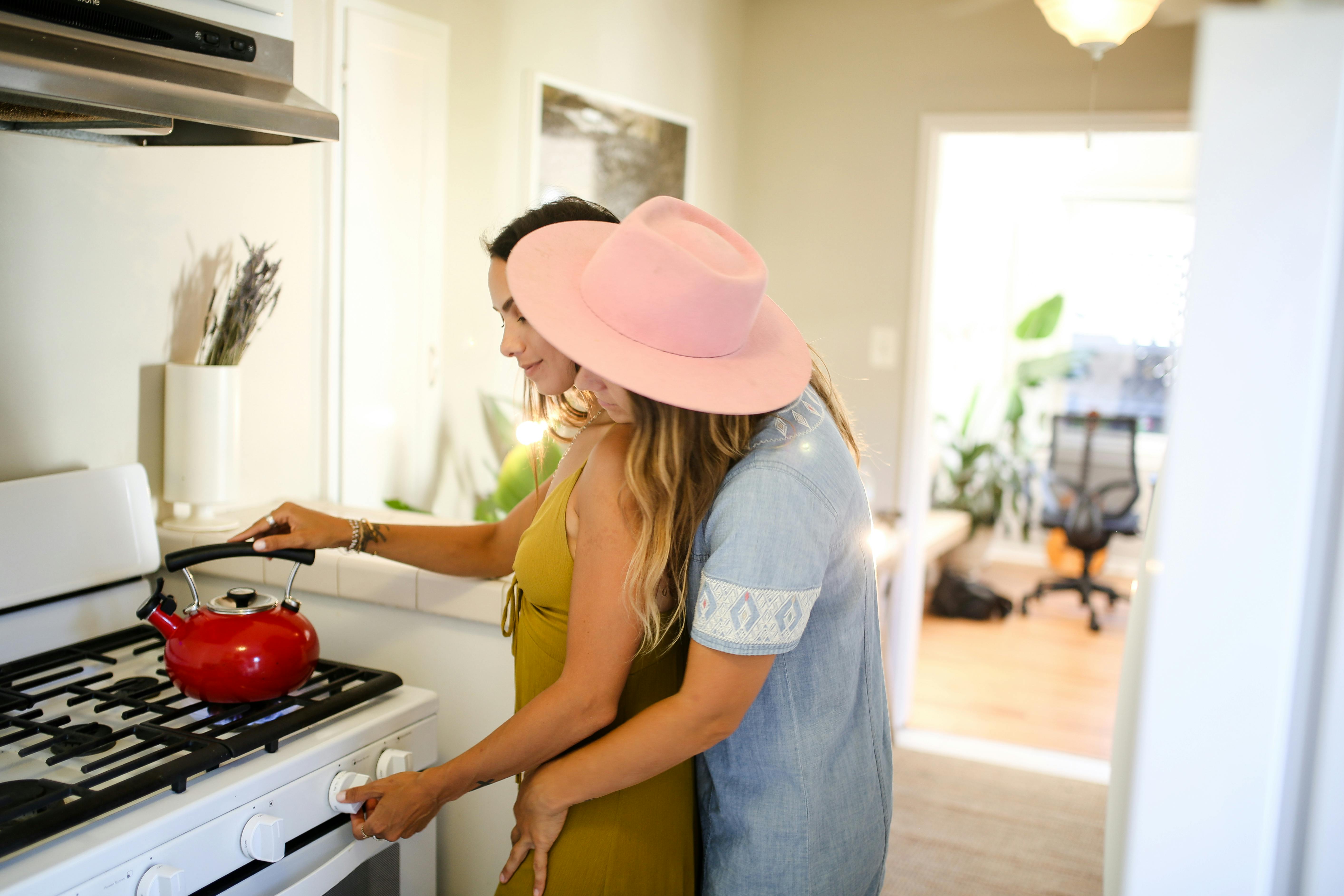 A loving couple enjoys quality time cooking in a cozy, modern kitchen setting.