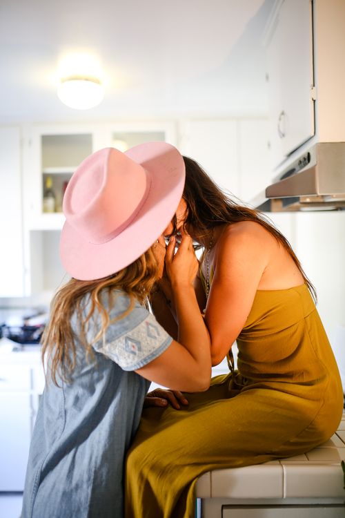 Free A tender moment shared between two women in a cozy kitchen setting. Stock Photo
