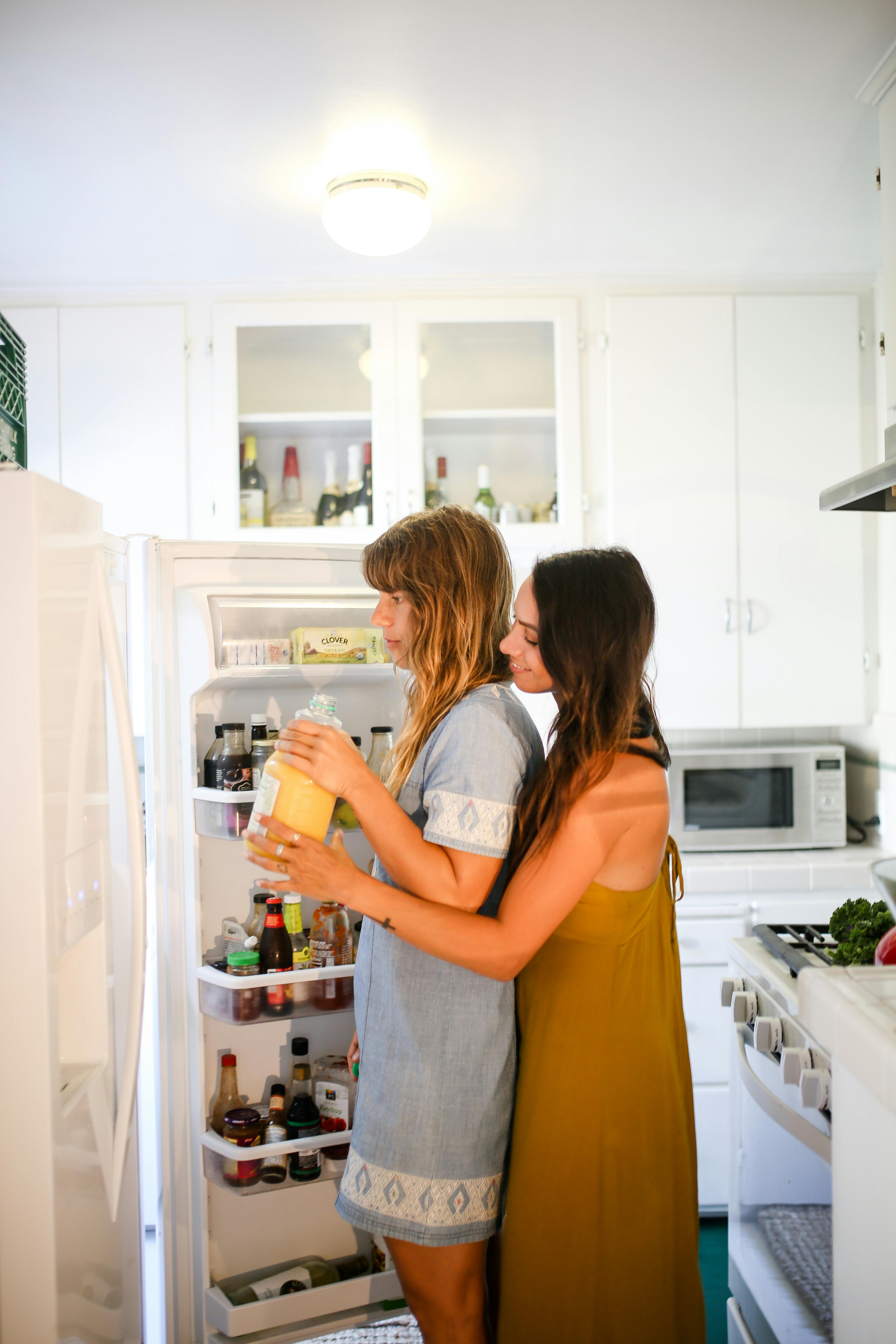 women standing in front of a refrigerator