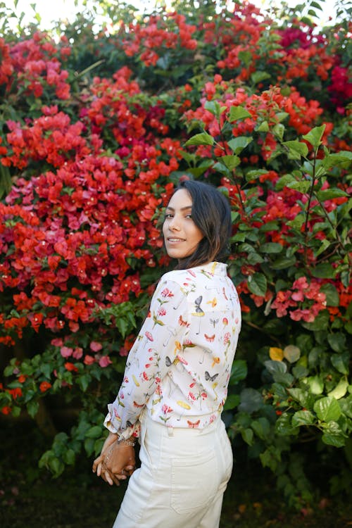 Beautiful Woman standing in front of Flowering Plant 