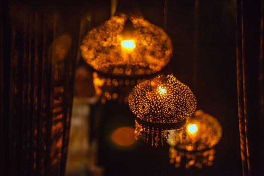 Glowing oriental lamps hanging on ceiling