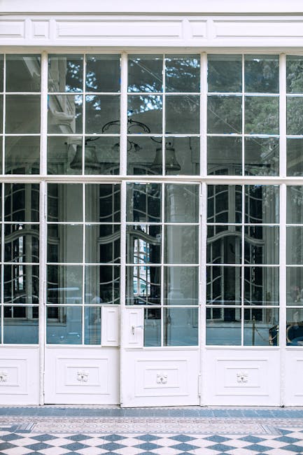Transparent glass wall in wooden frame of building with chandelier hanging on ceiling