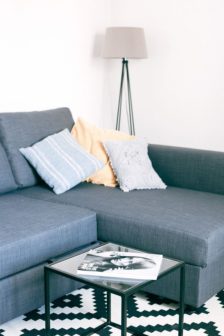 Room interior with decorative cushions on soft couch near square shaped table on carpet at home