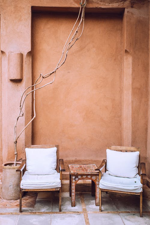 Aged armchairs near small table in patio