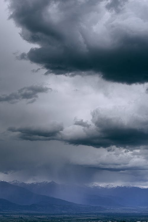 Gloomy sky over snowy mounts in fog