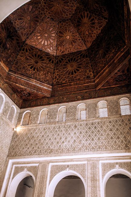 From below of aged masonry building interior with arches and shiny lamp on decorative wall