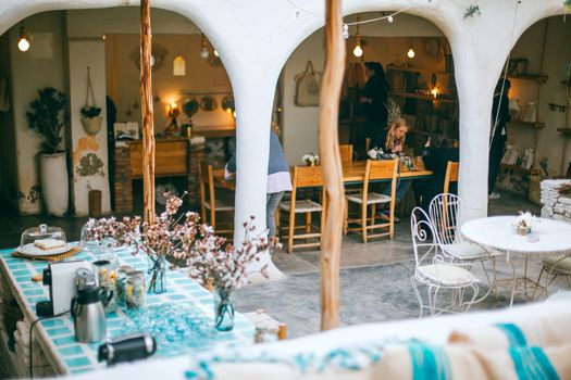 Charmant café en plein air avec décor rustique et tables à manger, parfait pour un rassemblement décontracté.