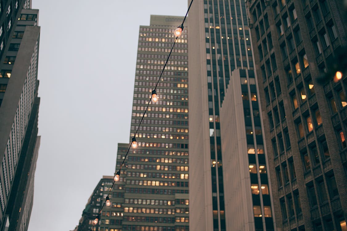 Modern skyscraper facades near shiny garland in evening