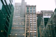 低角度下，高大现代建筑的外墙在城镇白色天空的映衬下闪闪发亮