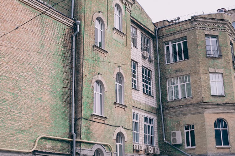 Facade Of Old Brick Building Against Overcast Sky