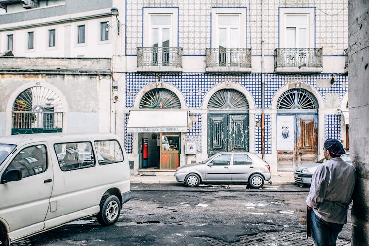 Unrecognizable Ethnic Man Against Old House Facade On City Street