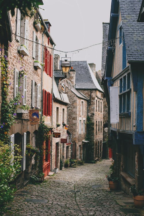 Narrow pedestrian street with brick residential houses in historic town district on cloudy day