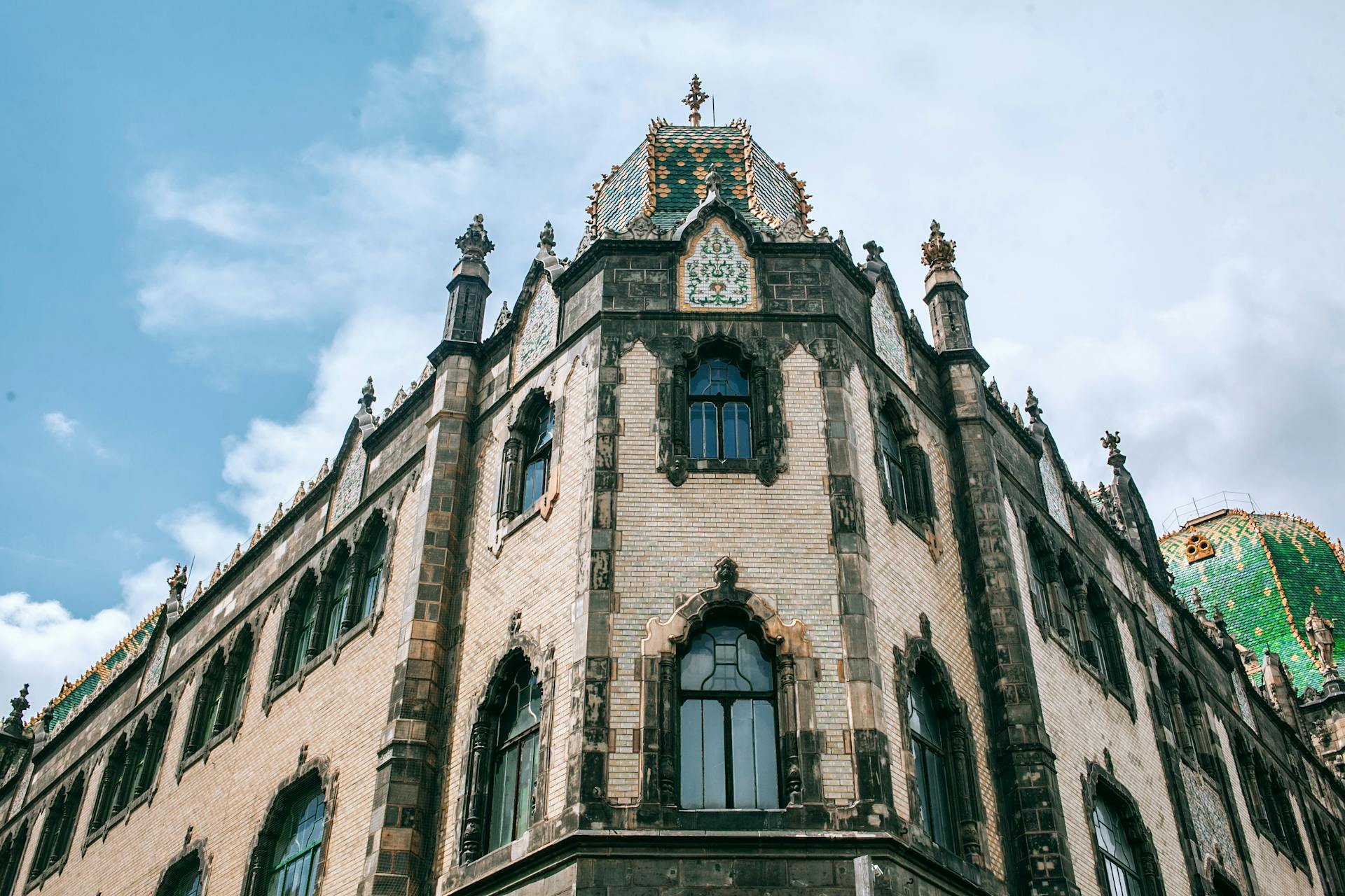 Low angle of old stone building facade with arched windows and ornamental walls in Hungary