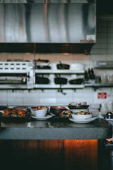 A cozy restaurant kitchen showing a variety of prepared dishes on a counter.