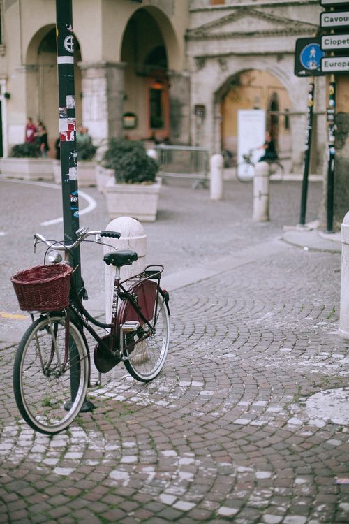 Free Retro bicycle with wicker basket parked on pavement near asphalt road in old city Stock Photo