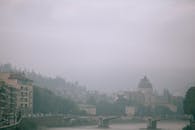 薄雾笼罩的欧洲城市景观宁静祥和，历史建筑与平静的河流尽收眼底