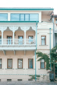 Exterior of contemporary classic apartment building with white ornamental balconies in modern city in daylight