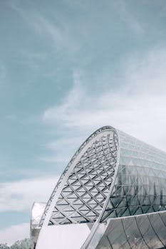 蔚蓝的天空下，矗立着具有几何设计的未来派玻璃结构