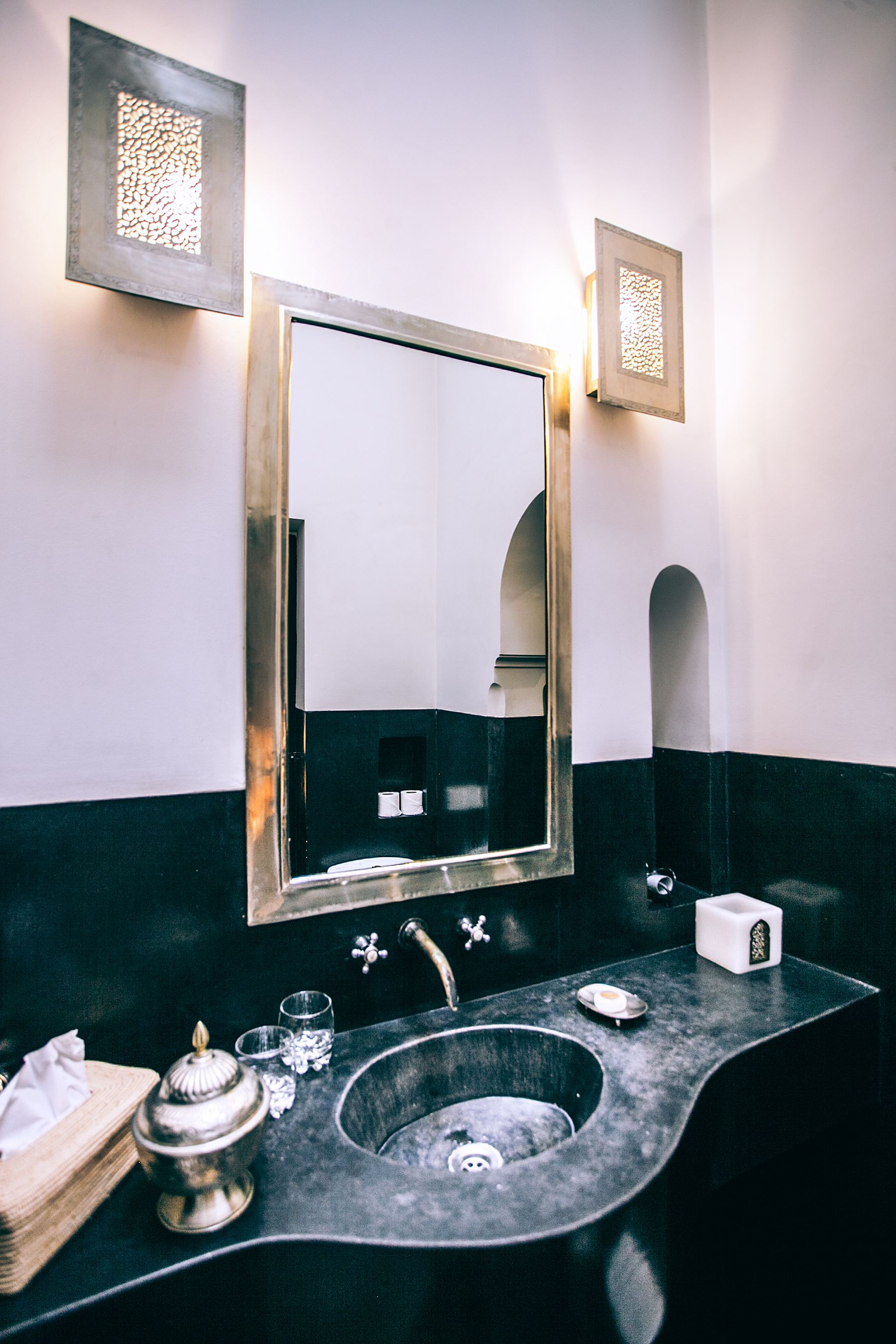Bathroom vanity with dark countertop, pale walls and restrained contemporary fittings