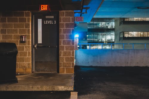 Free Exterior of concrete shabby building with luminous lights and balcony in late dusky evening Stock Photo