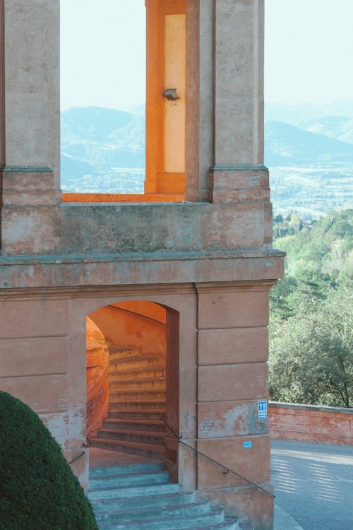 Ancient stone building with arch doorway and windows and shabby walls located in mountainous terrain