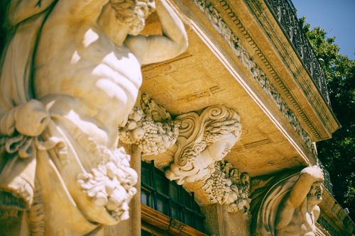 Free From below of aged stone sculptures located near entrance of old medieval building Stock Photo