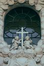 Window of old church decorated with ornamental relief elements and sculptures of little angels