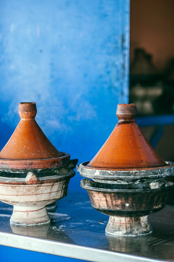 Traditional Moroccan heat resistant tajines with cone shaped covers and circular base on table