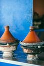 Traditional Moroccan heat resistant tajines with cone shaped covers and circular base on table