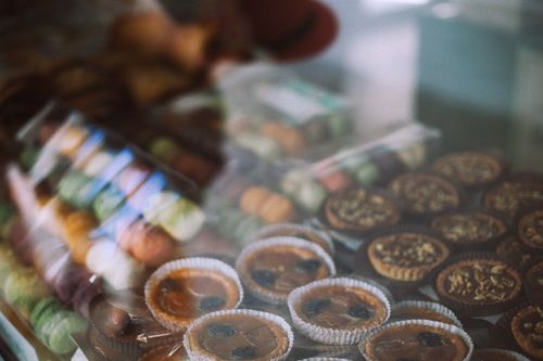Free Through glass view of different tasty tartlets and macaroons for sale in sweet shop Stock Photo