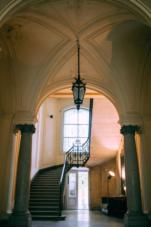 Free From below of aged house interior with decorative vault and staircase near shiny window Stock Photo