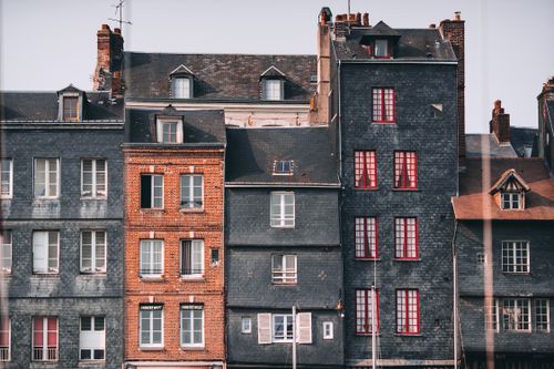Free Row of old historic stone residential houses with chimneys and windows located in Honfleur town on sunny day Stock Photo