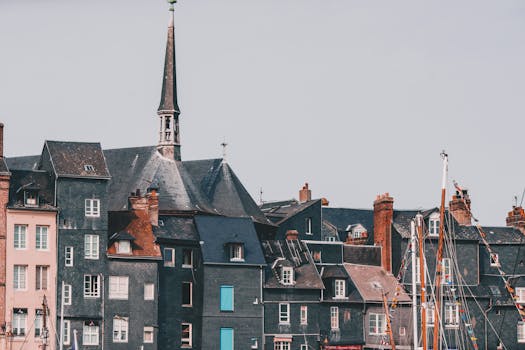 Charming historic buildings and church spire at Honfleur harbor in Normandy, France.