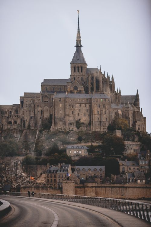 Free Exterior of famous Gothic styled Mont Saint Michel Abbey located on island against cloudy sky in France Stock Photo