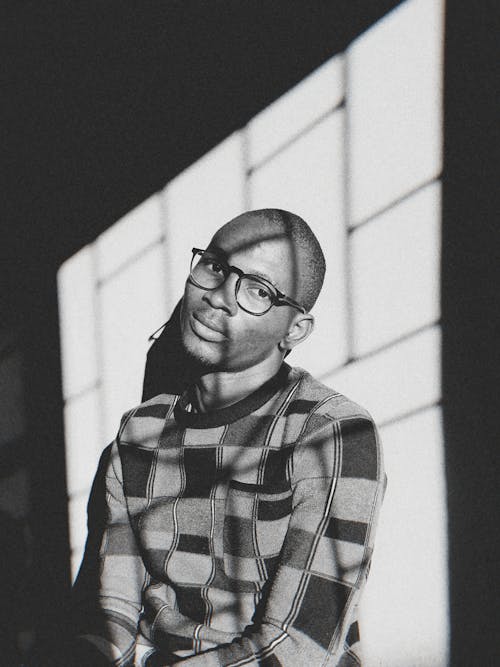 A Grayscale of a Man Wearing a Checkered Sweater