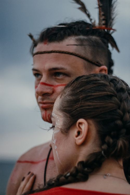 Free Artistic close-up of a couple with ceremonial face paint and braided hair, capturing intimacy and cultural expression. Stock Photo