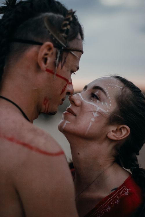 Free Intimate moment between a couple with artistic face paint, capturing affection and romance. Stock Photo