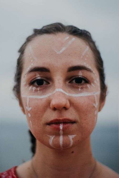 Free Intricate face paint adorns a woman's face in a captivating close-up portrait outdoors. Stock Photo