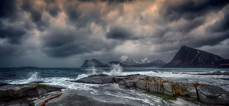 Stormy sea with rocky coastlines under a dramatic sky in Nordland, Norway.