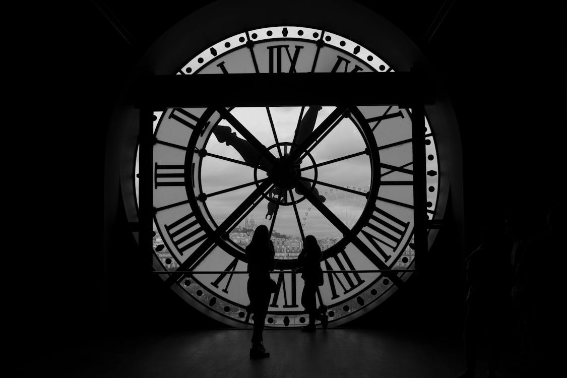 Free A Silhouette of People Standing Near the Clock of Musee D Orsay in Paris, France Stock Photo