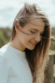 夏日乡村的户外，一位年轻女子微笑着，发丝随风轻扬