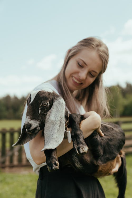 Woman in White Shirt Holding Black and White Bird