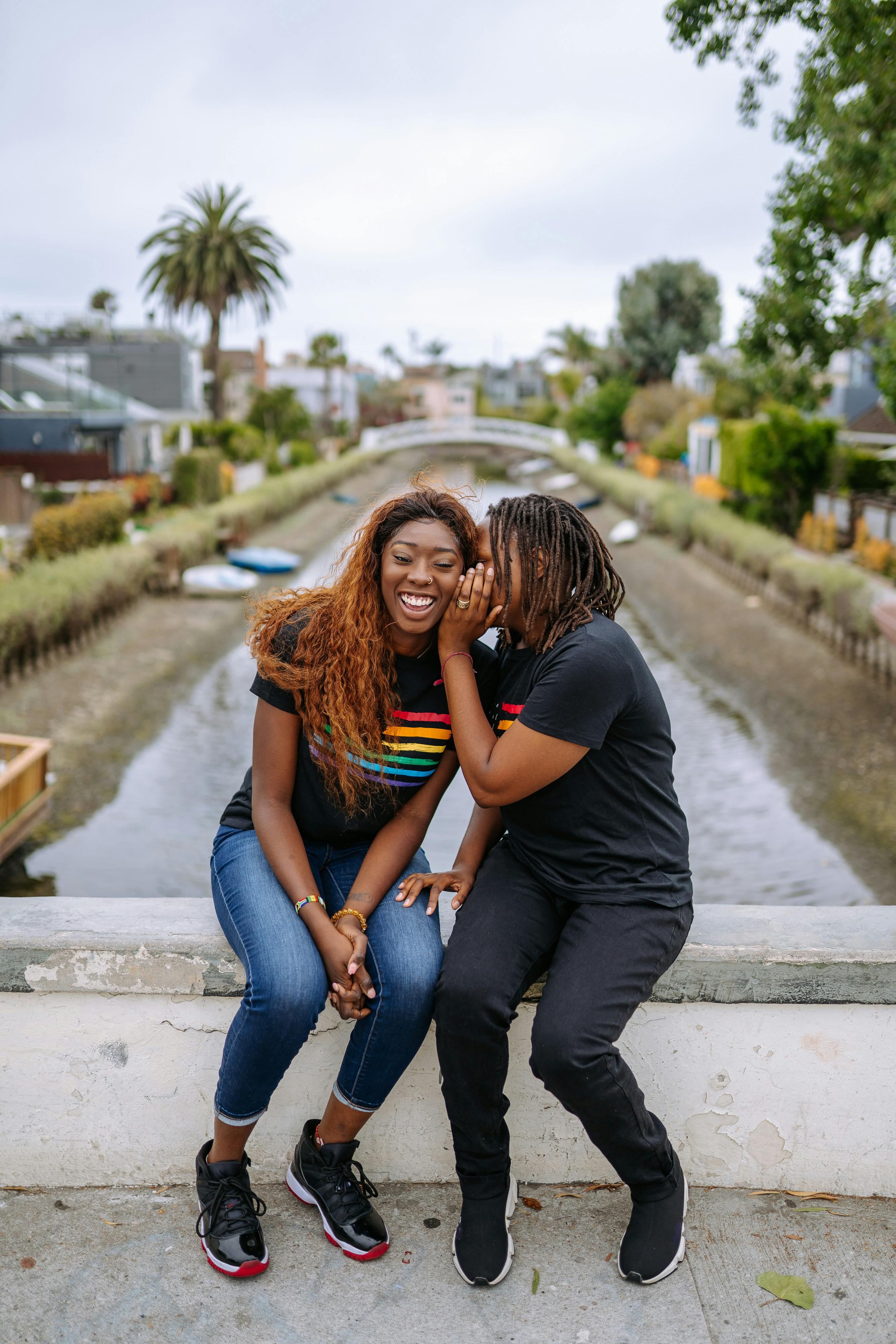 2 women standing on gray concrete road