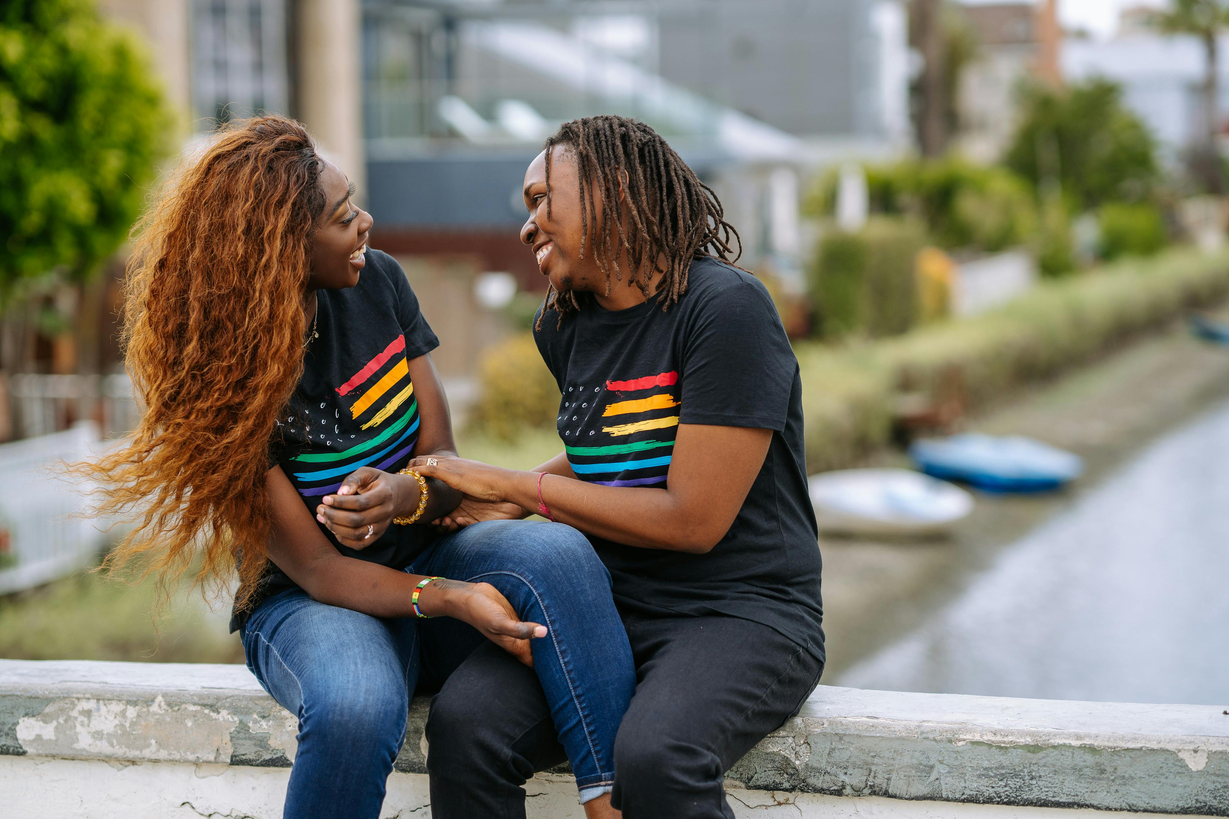 happy couple sitting on a concrete surface