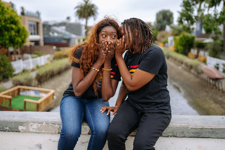 A Person Whispering To A Woman