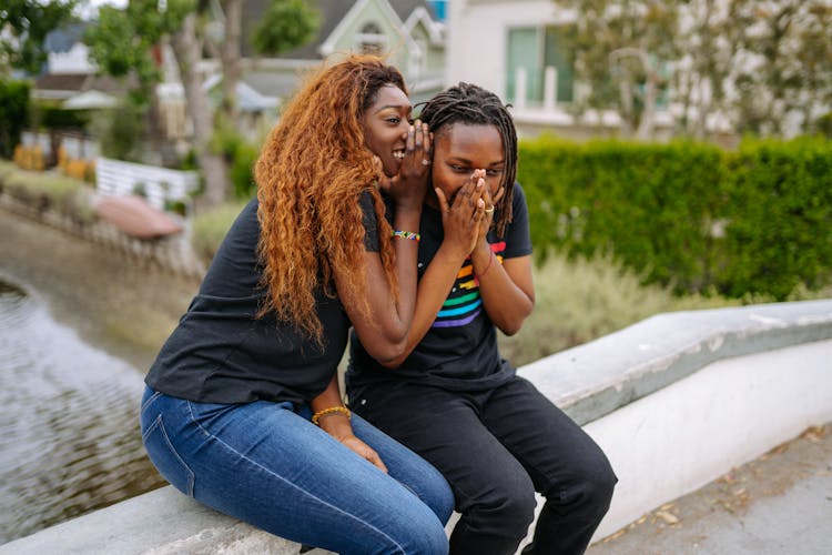 A Woman Whispering To A Person