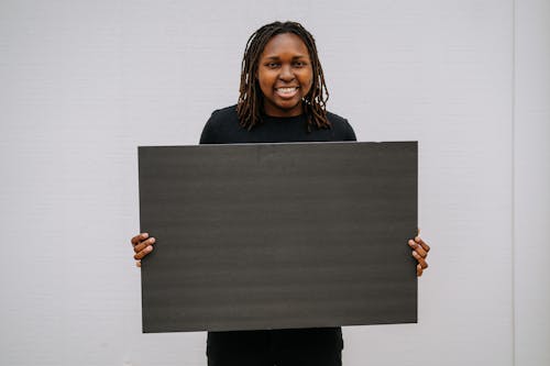 A Smiling Woman Holding a Blank Placard