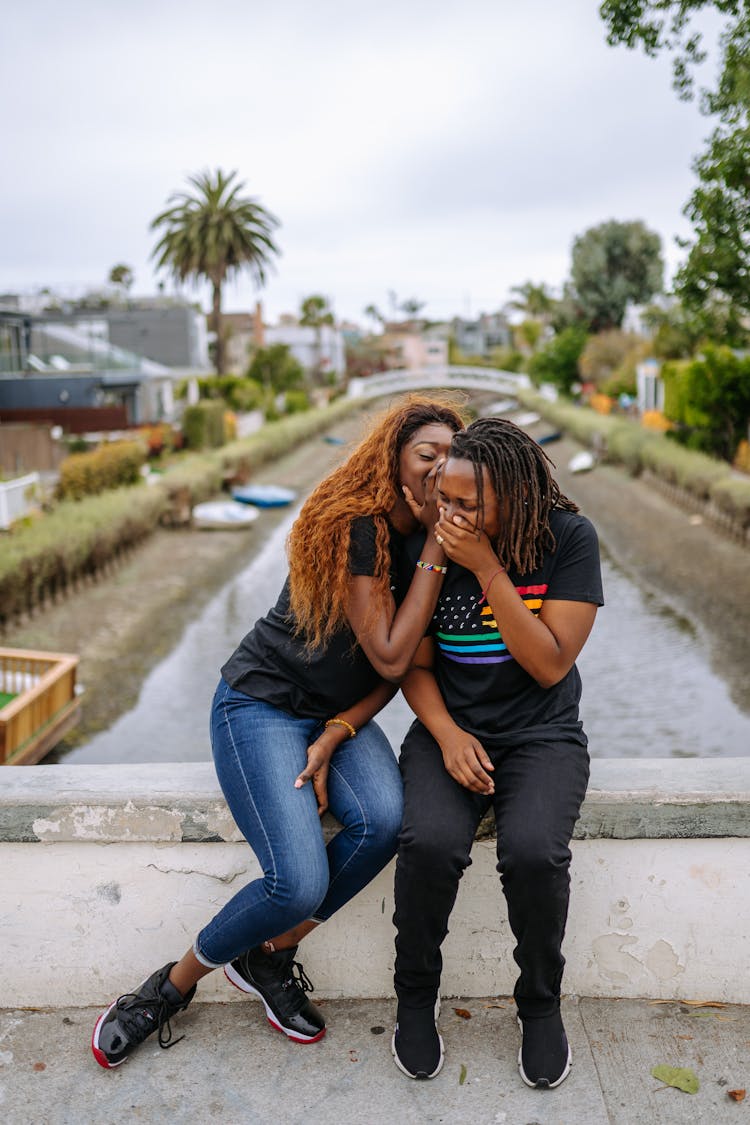 A Woman Whispering To A Person